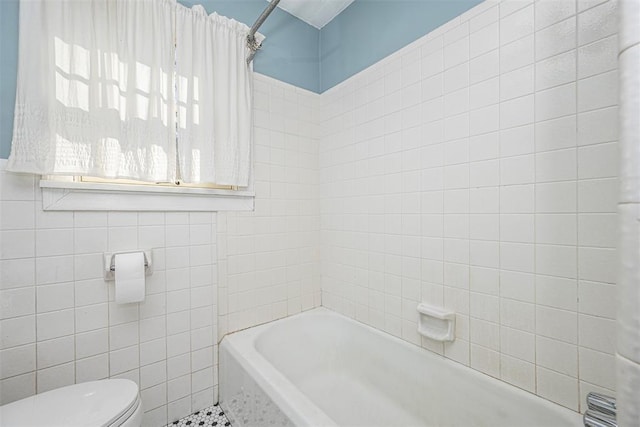 bathroom featuring tile walls and toilet