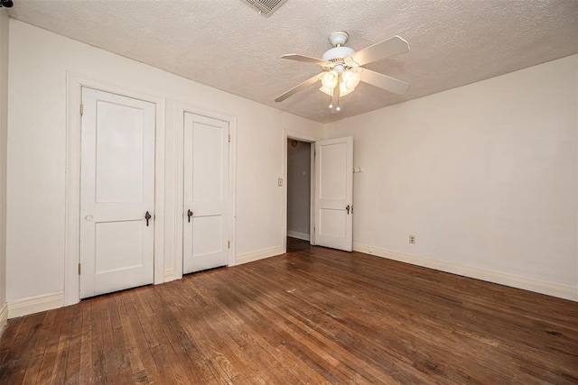 unfurnished bedroom featuring a ceiling fan, baseboards, visible vents, hardwood / wood-style flooring, and a textured ceiling