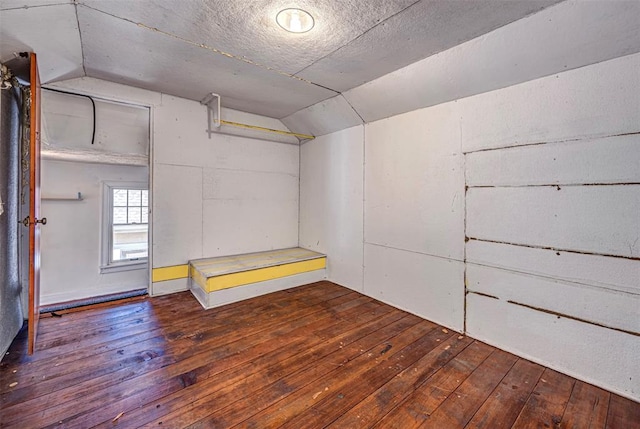 interior space with a textured ceiling, lofted ceiling, and hardwood / wood-style flooring