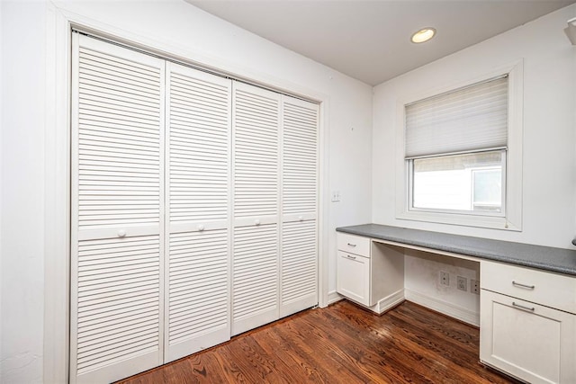 unfurnished office featuring recessed lighting, dark wood-style floors, baseboards, and built in study area