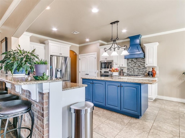 kitchen with premium range hood, blue cabinets, a center island with sink, arched walkways, and appliances with stainless steel finishes