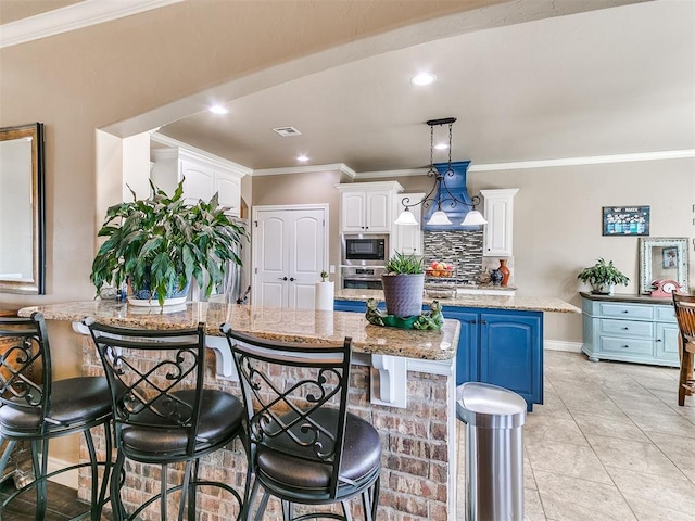 kitchen featuring backsplash, white cabinets, crown molding, and stainless steel oven