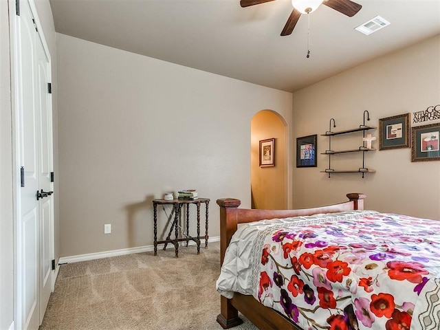 bedroom featuring visible vents, ceiling fan, baseboards, carpet flooring, and arched walkways