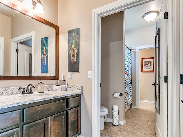 bathroom with vanity, a shower with shower curtain, toilet, and baseboards