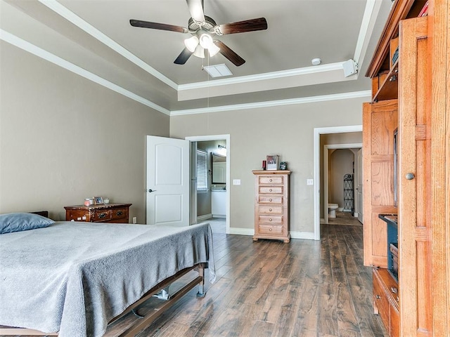 bedroom featuring connected bathroom, crown molding, baseboards, a raised ceiling, and dark wood-style flooring