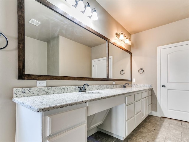 bathroom with a sink, baseboards, and double vanity