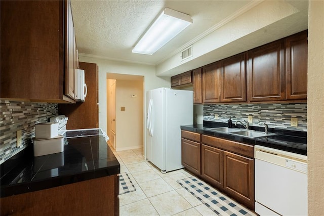 kitchen with visible vents, a sink, white appliances, crown molding, and light tile patterned floors