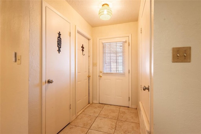 doorway to outside with light tile patterned flooring