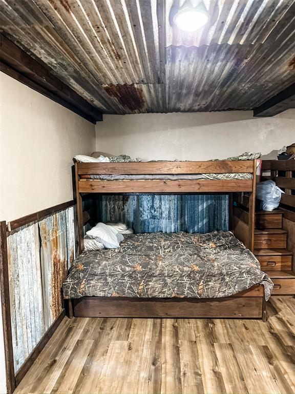 bedroom with wooden ceiling and wood finished floors