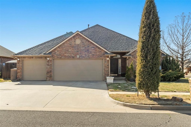 view of front facade with concrete driveway, a garage, brick siding, and a shingled roof