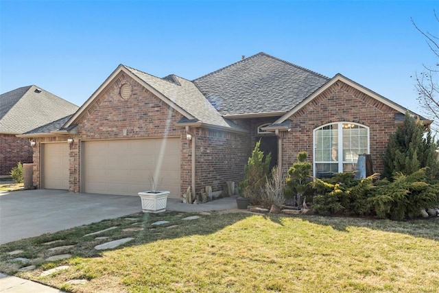 ranch-style house featuring a front yard, driveway, roof with shingles, a garage, and brick siding