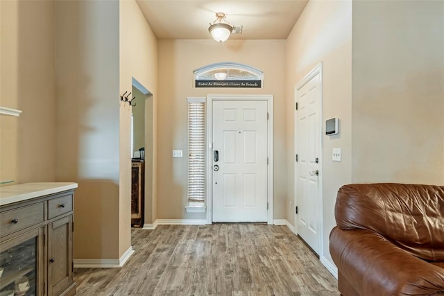 foyer featuring baseboards and light wood-type flooring