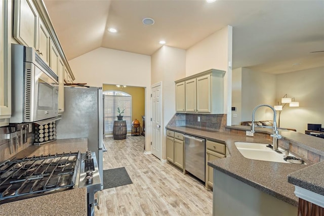 kitchen featuring a sink, dark countertops, appliances with stainless steel finishes, and a peninsula