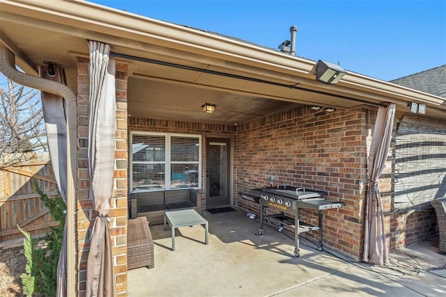 view of patio featuring fence and a grill