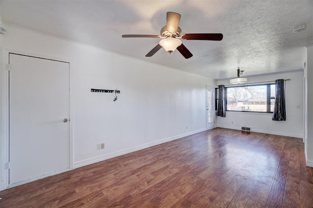 unfurnished room featuring visible vents, a textured ceiling, baseboards, and wood finished floors