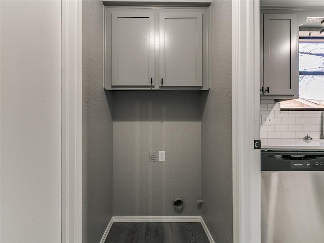 washroom with electric dryer hookup, baseboards, wood finished floors, and a textured wall