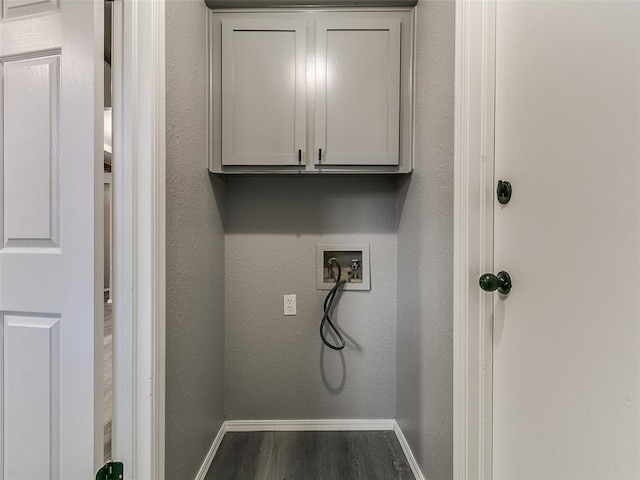 washroom with baseboards, cabinet space, washer hookup, and wood finished floors