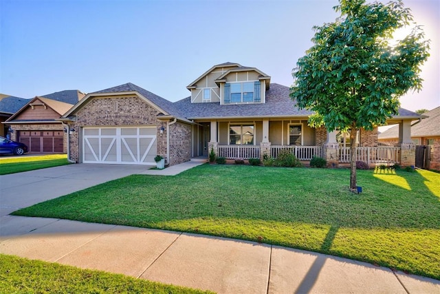 craftsman house featuring an attached garage, covered porch, a front lawn, concrete driveway, and brick siding