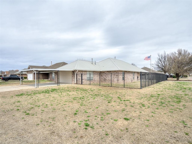 back of house with a carport, driveway, brick siding, and fence