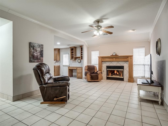 living area featuring light tile patterned floors, a fireplace, crown molding, and baseboards