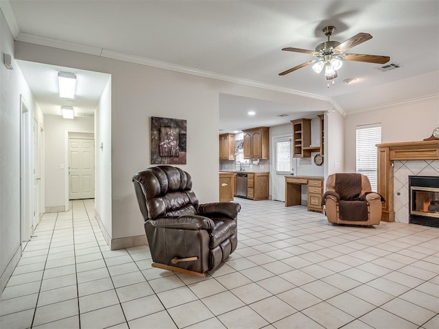 living room featuring visible vents, light tile patterned flooring, crown molding, and a tile fireplace