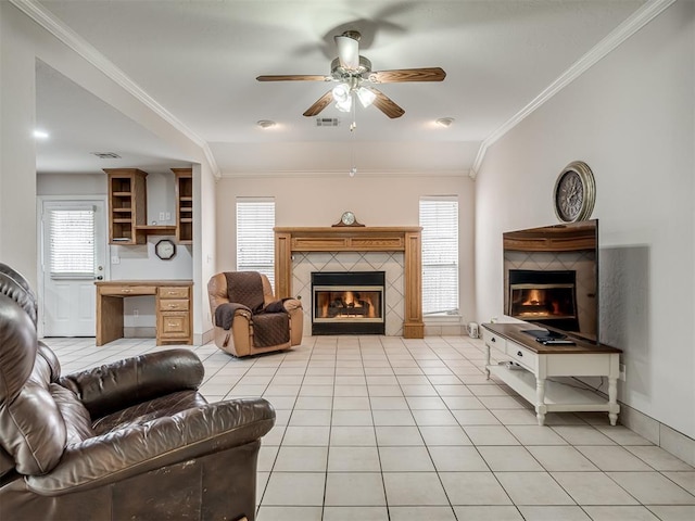 living area with a tiled fireplace, crown molding, light tile patterned floors, and visible vents