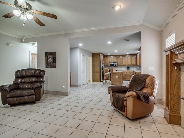 living room featuring light tile patterned flooring, baseboards, and ornamental molding