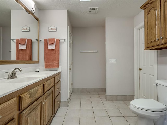 bathroom with vanity, visible vents, a textured ceiling, tile patterned floors, and toilet