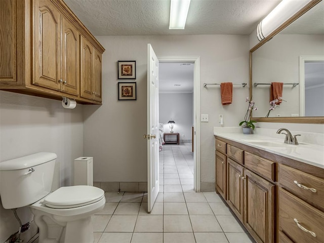 bathroom featuring baseboards, toilet, vanity, tile patterned floors, and a textured ceiling