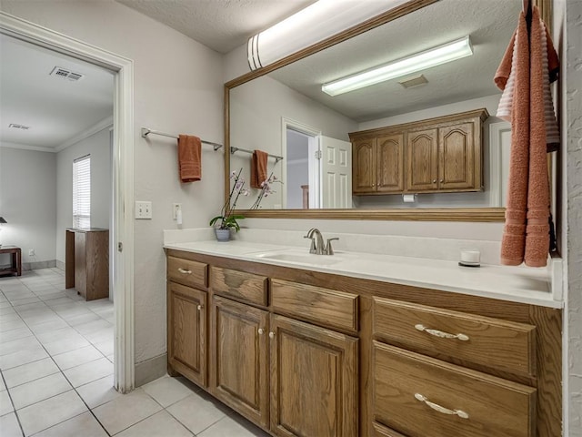 bathroom with vanity, visible vents, ornamental molding, a textured ceiling, and tile patterned floors