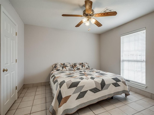 bedroom with visible vents, baseboards, light tile patterned flooring, and a ceiling fan