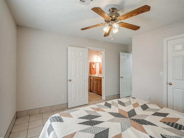 bedroom with visible vents, ensuite bathroom, light tile patterned flooring, baseboards, and ceiling fan