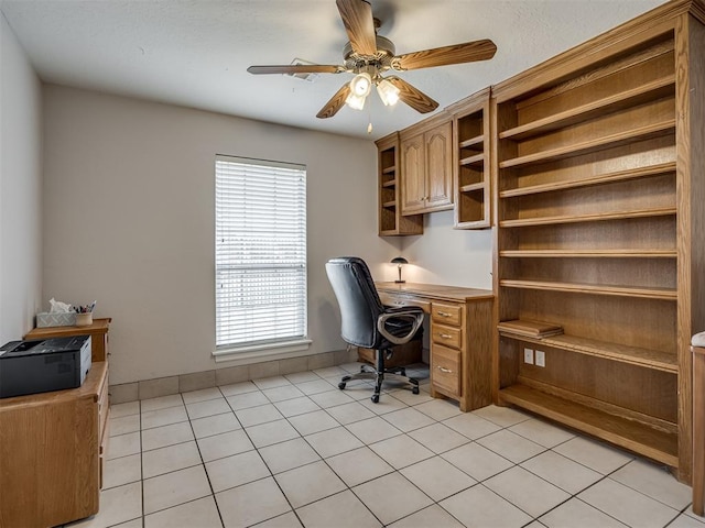 office featuring light tile patterned flooring, a ceiling fan, built in desk, and baseboards