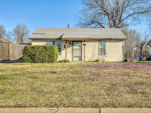 single story home featuring a front lawn and fence