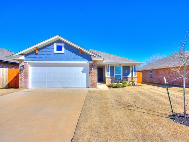 view of front of property with brick siding, driveway, an attached garage, and fence