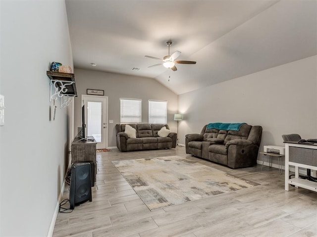 living area featuring visible vents, a ceiling fan, light wood finished floors, baseboards, and vaulted ceiling