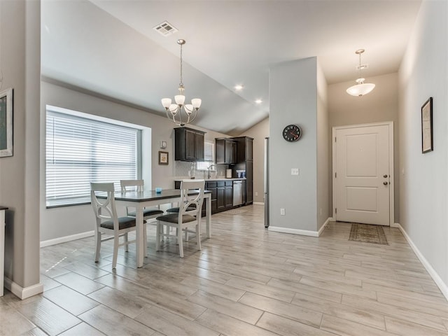 dining room featuring light wood-type flooring, visible vents, baseboards, and an inviting chandelier