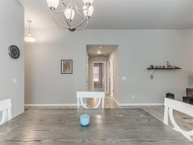 unfurnished dining area featuring visible vents, wood finished floors, and baseboards