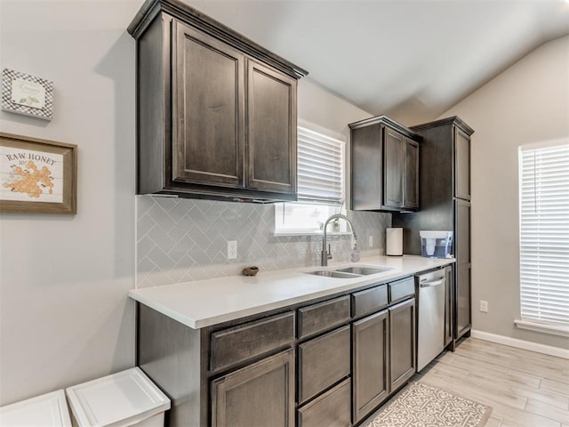 kitchen featuring a sink, backsplash, stainless steel dishwasher, and dark brown cabinetry