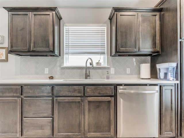 kitchen featuring tasteful backsplash, dark brown cabinets, dishwasher, and a sink