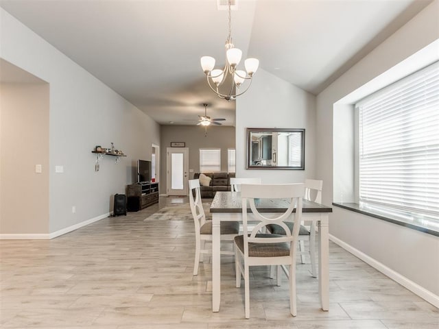 dining room featuring ceiling fan with notable chandelier, baseboards, light wood-type flooring, and lofted ceiling