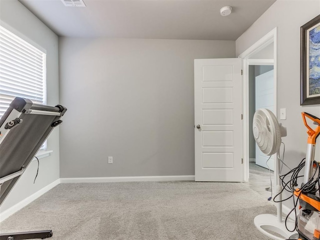 exercise area with visible vents, baseboards, and carpet floors