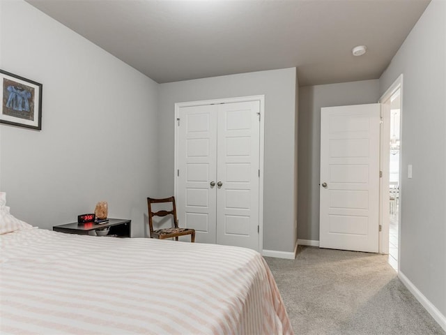 bedroom featuring a closet, baseboards, and carpet flooring