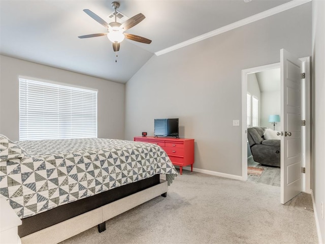 bedroom featuring baseboards, lofted ceiling, ceiling fan, crown molding, and carpet flooring