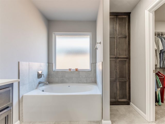 bathroom featuring a bath, vanity, and a walk in closet