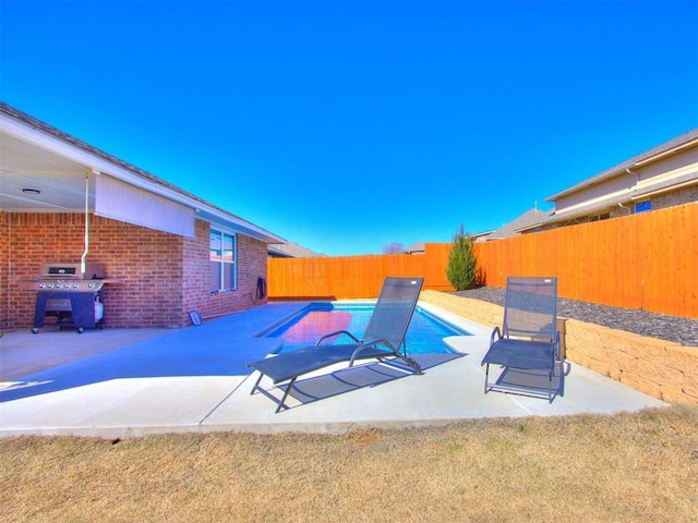 view of swimming pool with a fenced in pool, area for grilling, a fenced backyard, and a patio area