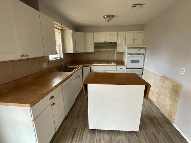 kitchen with visible vents, a sink, white appliances, white cabinets, and dark wood-style flooring