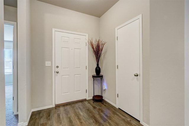 foyer featuring baseboards and wood finished floors