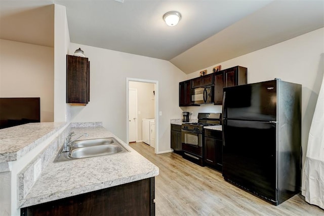 kitchen with black appliances, washer and clothes dryer, a sink, dark brown cabinetry, and light countertops