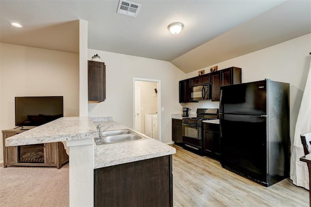 kitchen with visible vents, washing machine and dryer, a peninsula, black appliances, and a sink